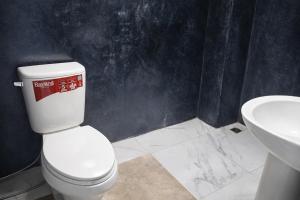 a bathroom with a white toilet and a sink at B&T Hostel in Ban Pa Tung (7)