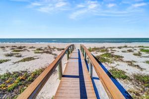 a wooden boardwalk leading to a sandy beach at Pass-A-Grille Beach Retreat Unit 8 in St. Pete Beach