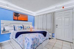 a blue bedroom with a bed and a white door at Pass-A-Grille Beach Retreat Unit 8 in St. Pete Beach