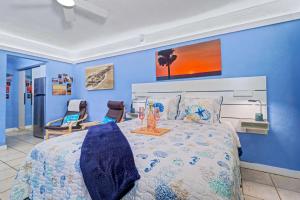 a blue bedroom with a bed and two chairs at Pass-A-Grille Beach Retreat Unit 8 in St. Pete Beach +17 photos