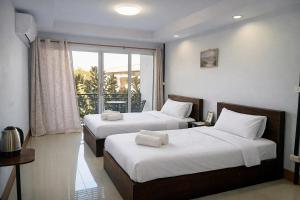 a hotel room with two beds and a balcony at B&T Hostel in Ban Pa Tung (7)