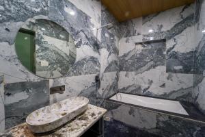 a bathroom with a sink and a mirror and a tub at Lumira Queensbury Villa in Udaipur +49 photos