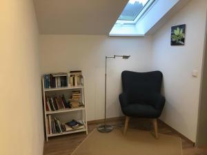 a room with a black chair and a book shelf at Ferienhaus Kollmer in Bad Koetzting