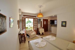 een woonkamer met 2 bedden en een keuken bij Alexandros Apartments & Studios in Agios Gordios