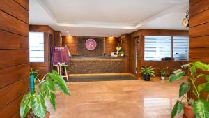 a lobby with wooden walls and plants and a counter at Yashshree Sanderling Mall Road in Darjeeling