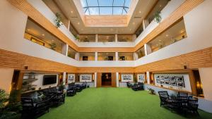 a large room with chairs and a green floor at Yashshree Sanderling Mall Road in Darjeeling
