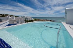 a swimming pool with a view of the ocean at Seehuis Studios in Langebaan