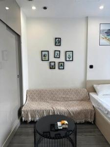 a bedroom with a bed and a table with pictures on the wall at R1 Studio Ruby Zenpark in Gia Lâm Pho