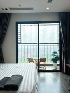 a bedroom with a bed and a large window at R1 Studio Ruby Zenpark in Gia Lâm Pho