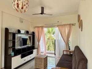 a living room with a couch and a television at Between Tides nd Toasts Udupi Manipal in Manipal