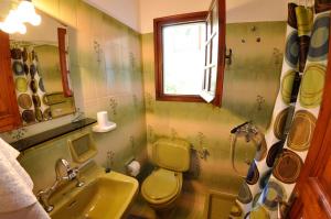 een badkamer met een wastafel, een toilet en een raam bij Alexandros Apartments & Studios in Agios Gordios