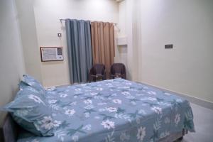 a hospital room with a bed and two chairs at Narayan Homestay & Guest House in Haridwār +3 photos