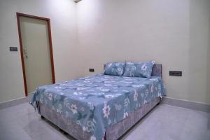 a bedroom with a bed with a blue comforter at Narayan Homestay & Guest House in Haridwār