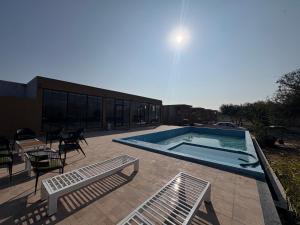 a swimming pool with chairs and a table and a building at Jalsa Jawai Resort in Bīsalpur +8 photos