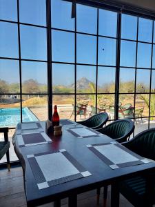 a dining room with a table and chairs and a large window at Jalsa Jawai Resort in Bīsalpur