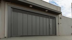 a garage with two garage doors on a building at Jahu Center Casas Un 5 in Jaú