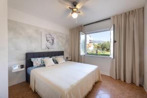 a bedroom with a bed with a ceiling fan and a window at Seaview Pool Villa with cinema up to 26 in Kaštela +90 photos