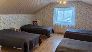 a room with three beds and a window at Kauppilan Matkailutalo in Ikaalinen +15 photos