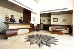 two men standing at a bar in a hotel lobby at Comfort Inn Sapphire - A Inde Hotel in Jaipur