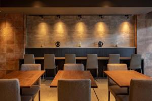 a dining room with wooden tables and chairs at The OneFive Osaka Shinsekai in Osaka