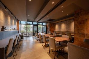 a dining room with wooden tables and chairs at The OneFive Osaka Shinsekai in Osaka