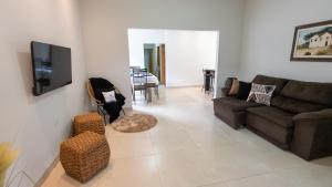 a living room with a couch and a tv at Jahu Center Casas Un 5 in Jaú