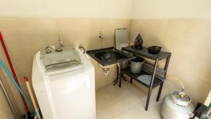 a small kitchen with a washing machine and a sink at Jahu Center Casas Un 5 in Jaú +24 photos