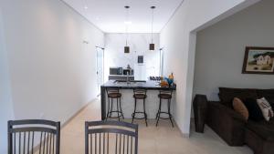 a living room with a couch and a kitchen with a counter at Jahu Center Casas Un 5 in Jaú