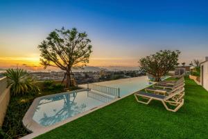 a pool on the roof of a house with lounge chairs at HOMA Chalong Bay in Ban Klang