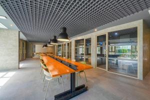 a long wooden table in a room with chairs at HOMA Chalong Bay in Ban Klang