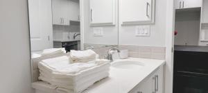 a white bathroom with a sink and a mirror at Cozy Luxe Suites in Calgary +33 photos