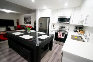 a kitchen with a black island in the middle at Cozy Luxe Suites in Calgary