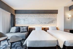 a hotel room with two beds and a couch at The OneFive Osaka Shinsekai in Osaka +19 photos