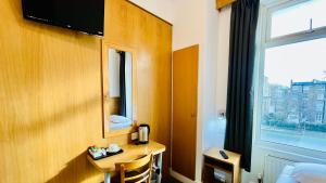 a hotel room with a desk and a window at West Cromwell Hotel in London