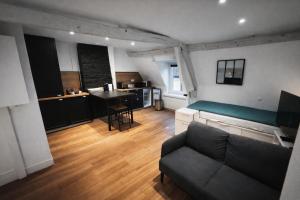 a living room with a couch and a table in it at Le Nid Beauvaisien in Beauvais