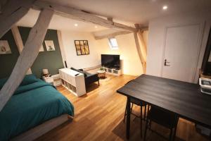 a bedroom with a bed and a table in a room at Le Nid Beauvaisien in Beauvais