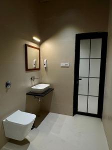 a bathroom with a toilet and a sink and a mirror at Jalsa Jawai Resort in Bīsalpur