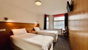 a hotel room with two beds and a window at West Cromwell Hotel in London
