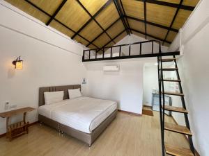 a bedroom with a loft bed and a ladder at โรงแรมสบายดีรีสอร์ท in Tha Bo