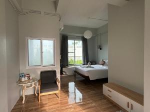a bedroom with a bed and a table and a window at T terrest Residence in Thai Muang