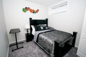 a bedroom with a black bed and a window at Cozy Luxe Suites in Calgary