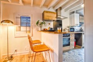a kitchen with a counter and a chair in a room at La Cime - Duplex hypercentre, Wi-Fi & restaurant in Caen +16 photos