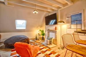 a living room with orange chairs and a fireplace at La Cime - Duplex hypercentre, Wi-Fi & restaurant in Caen