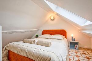 a bedroom with an orange bed in a attic at La Cime - Duplex hypercentre, Wi-Fi & restaurant in Caen