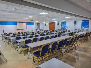 a conference room with tables and chairs and a screen at Hotel Sapphire in Mombasa +57 photos