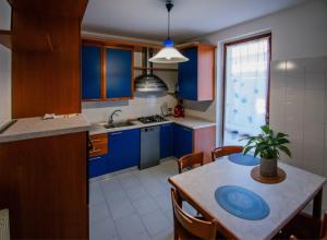 a kitchen with blue cabinets and a table with a potted plant at La casa di a-mici in Maccagno Superiore