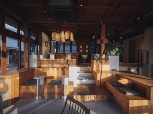ein Restaurant mit Holztischen und -stühlen in einem Raum in der Unterkunft SOIL Setoda in Onomichi
