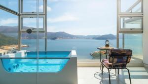 a glass house with a view of the water at Geoje Badageurigo Pension in Geoje