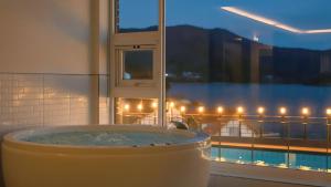 a bath tub in a bathroom with a window at Geoje Badageurigo Pension in Geoje +2 photos