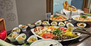 a buffet with many plates of food on a table at Ringhotel Schorfheide I Waldresort Werbellinsee in Joachimsthal +128 photos